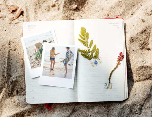 Dodatek do tekstu o tym, jak ułatwić sobie życie na studiach. Przedstawia brulion - leżący na piasku- z pamiątkami - zdjęciami z wakacji i zasuszonym liściem.
